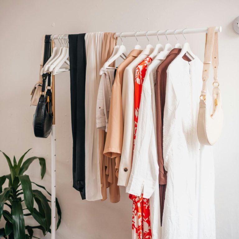 Wardrobe reset package A rack displaying a selection of stylish clothing in various colours.